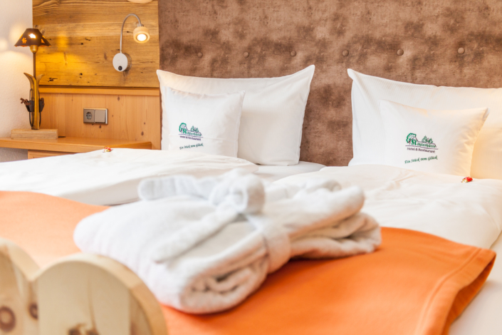 Zusammengelegte Bademäntel auf dem Bett