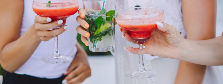 Frauen stoßen mit Cocktails an